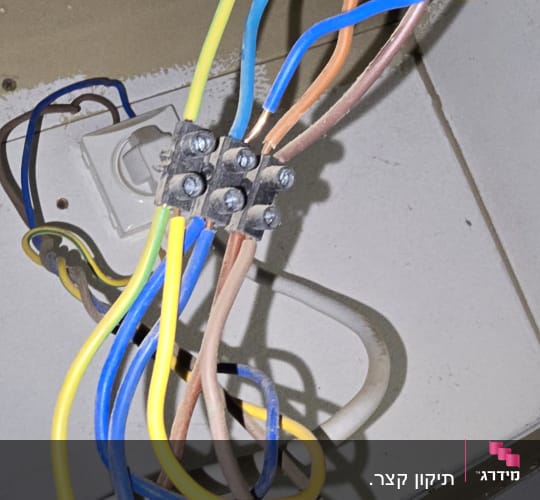 חוטי חשמל צבעוניים מחוברים לקופסת חיבורים